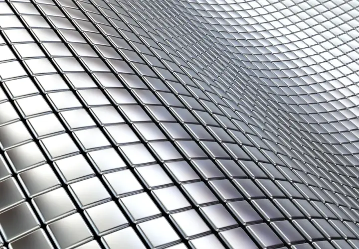 Metaliczne kwadraty tworzą falistą powierzchnię, przypominającą tabelę gatunków stali nierdzewnej.