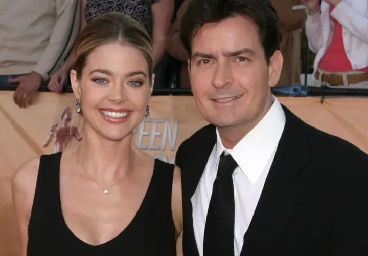 Charlie Sheen i jego żona, Denise Richards, uśmiechają się do aparatu na czerwonym dywanie.