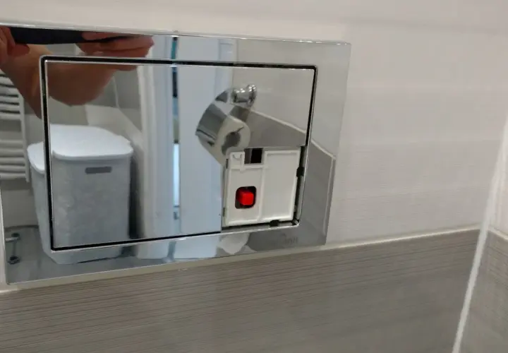 Jak zdjąć przycisk spłuczki podtynkowej Cersanit? Widoczny mechanizm z czerwonym przyciskiem.