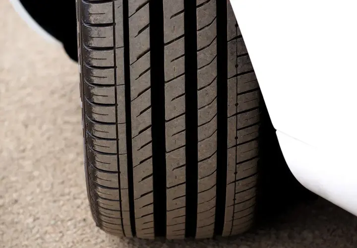 Gros plan sur un pneu 4 saisons, prêt pour le test. Sa bande de roulement profonde promet une bonne adhérence sur toutes les surfaces.