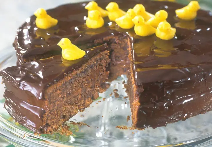 En saftig chokladkaka med blank glasyr, dekorerad med små gula kycklingar. En perfekt påsktårta för alla chokladälskare!