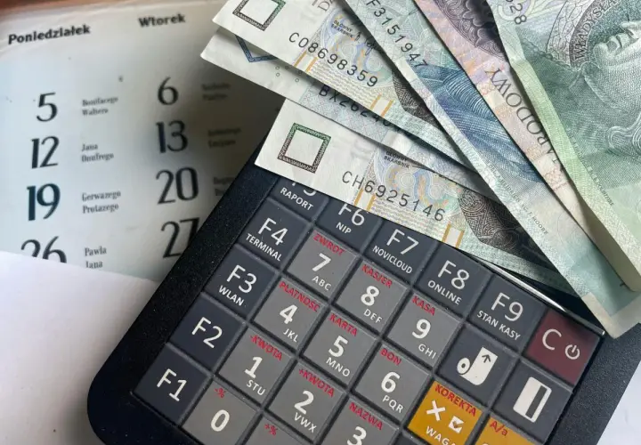 Kalkulator, banknoty i kalendarz. Planowanie wydatków na świadczenie urlopowe.