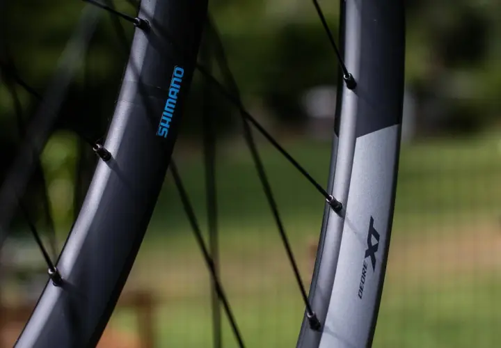 Close-up of two Shimano XT wheelsets, showcasing their durable construction and sleek design, ready for any trail.