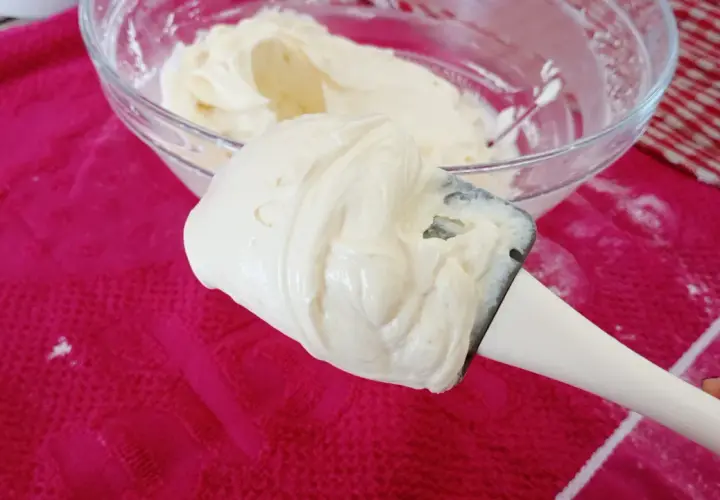 Crème onctueuse de mascarpone sur une spatule, prête pour une délicieuse recette.