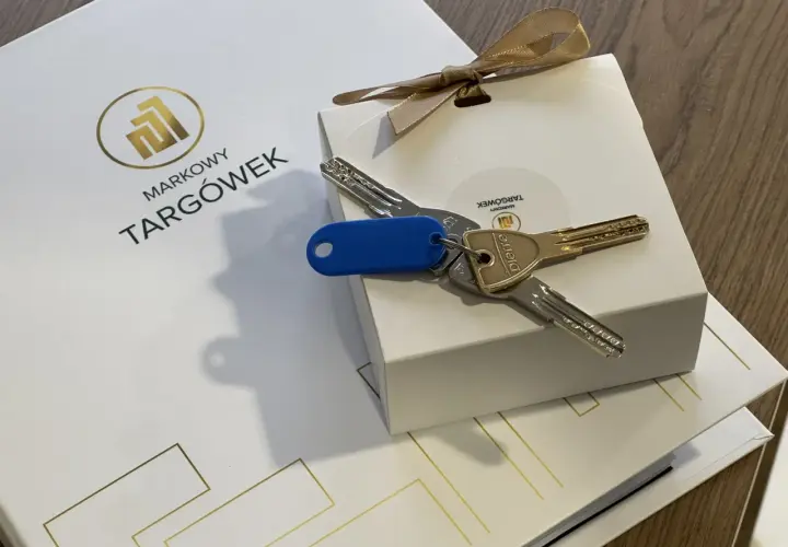 Klucze do nowego mieszkania na Markowym Targówku, zapakowane w eleganckie pudełko z logo.