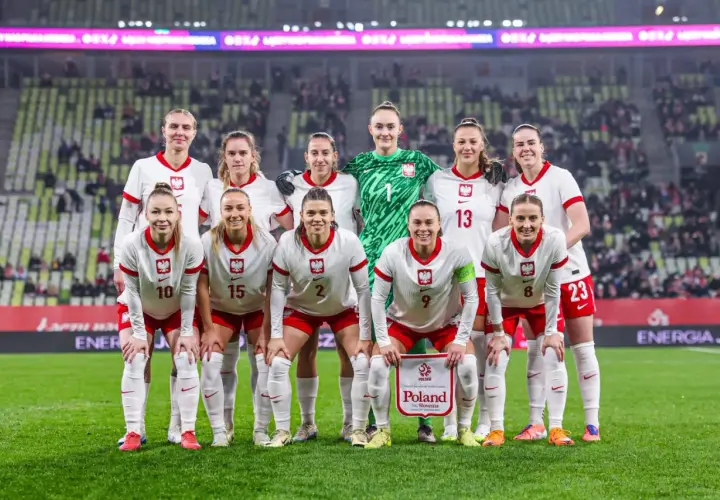 Reprezentacja Polski w piłce nożnej kobiet przed meczem z **Polska Słowenia**. Drużyna w białych strojach z orzełkiem na piersi.
