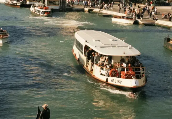 Ein belebter Vaporetto in Venedig transportiert Passagiere über das glitzernde Wasser.