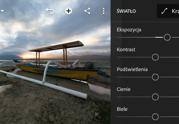 Łódź na plaży o zachodzie słońca, edytowana w trybie camera raw. Kontrolki ekspozycji, kontrastu, podświetleń, cieni i bieli.