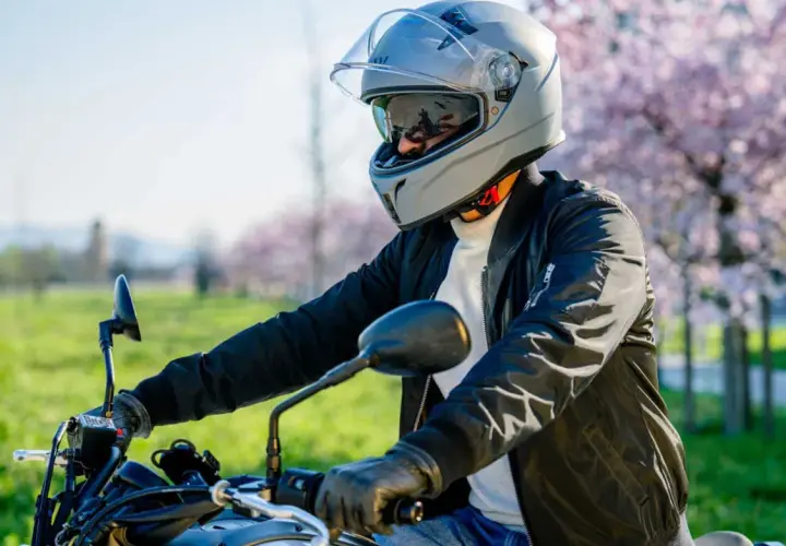 Motociclista con casco grigio, pronto per un giro. La scelta del giusto **misura casco moto** è fondamentale per la sicurezza.