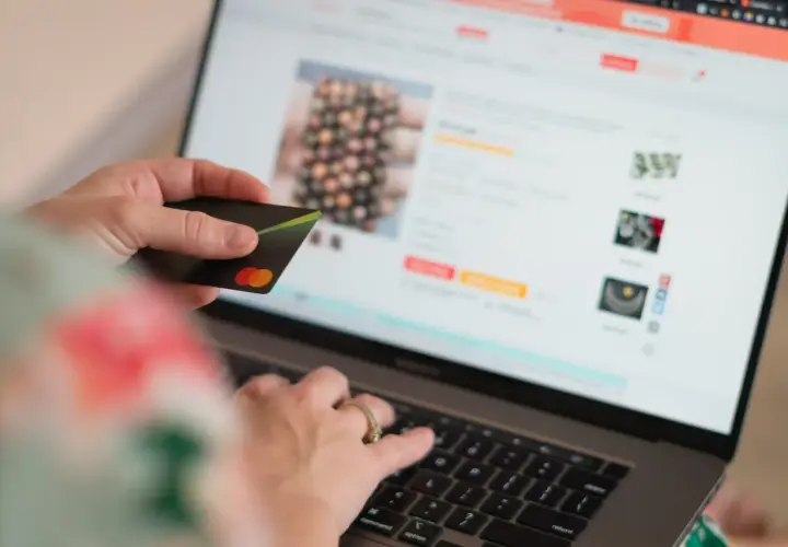 Persona compra en línea con tarjeta de crédito, dando su consentimiento explícito para la transacción.