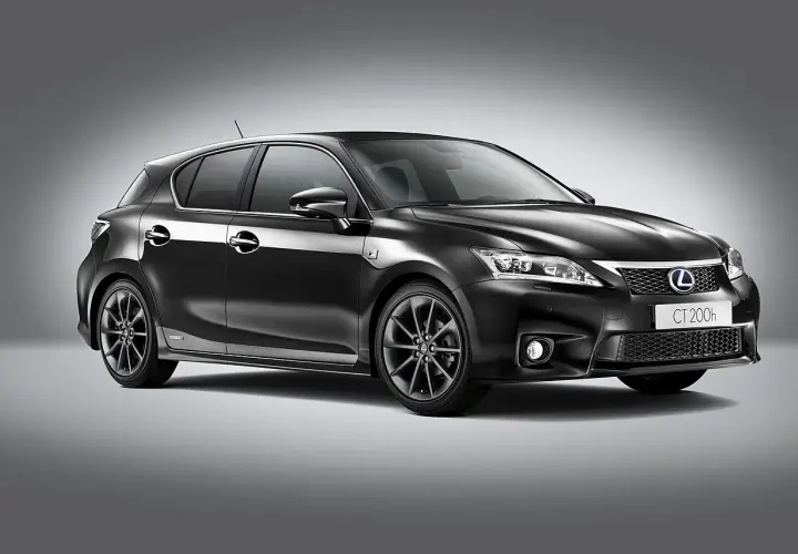 Elegancki, czarny Lexus CT200h z przyciemnianymi felgami stoi na szarym tle.