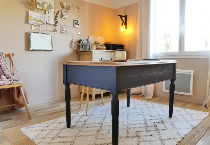 Bureau en bois peint en bleu marine, avec un plateau en bois naturel. Une tasse est posée sur le bureau.