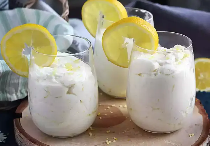 Trois verres de mousse au citron sans cuisson, décorés de rondelles de citron et de zeste. Un dessert frais et léger.