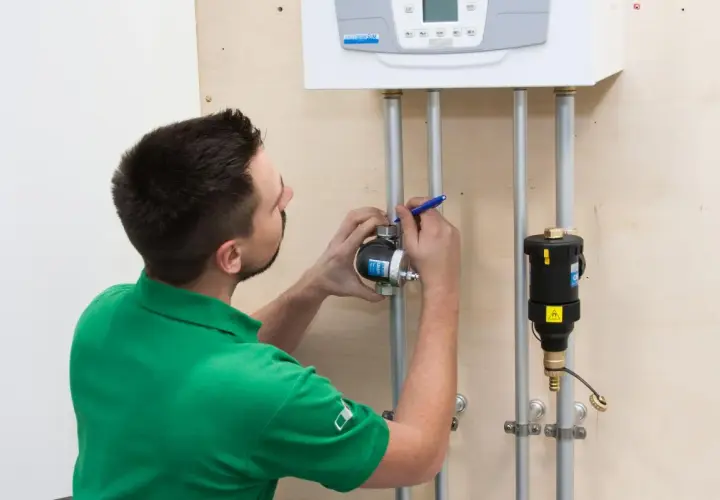 Instalator sprawdza, gdzie zamontować separator zanieczyszczeń przy kotle.