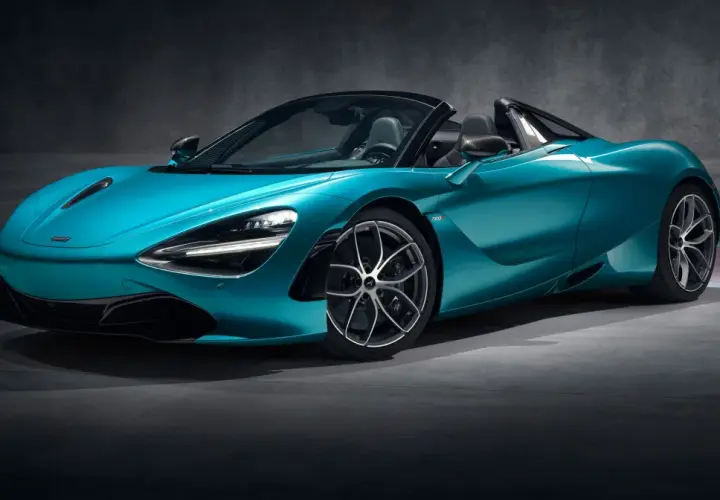 Turkusowy McLaren 720S Spider z otwartym dachem, gotowy do jazdy po torze.