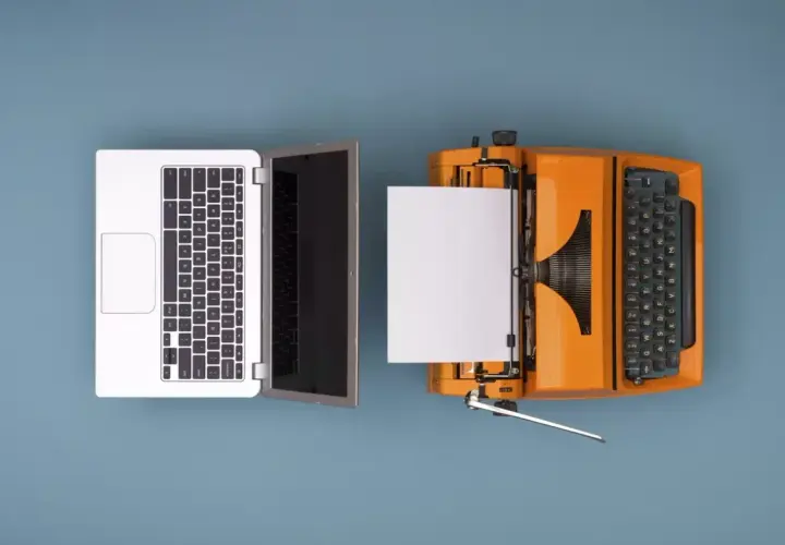 Un portátil y una máquina de escribir naranja con papel, ilustrando como se digitaliza un documento.