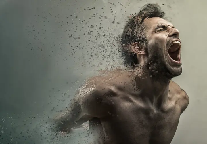 Uomo che urla, dissolvendosi in particelle, con un'espressione di profonda paura di impazzire.