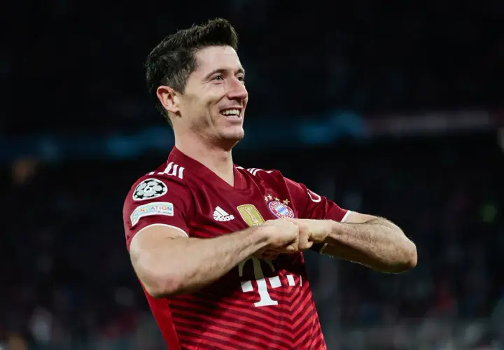Robert Lewandowski, jeden z najlepszych króli strzelców Bundesligi, świętuje gola w czerwonej koszulce Bayernu Monachium.
