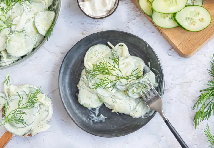 Cremiger Gurkensalat mit Schmand und frischem Dill, garniert mit Dillzweigen. Ein erfrischender Genuss!