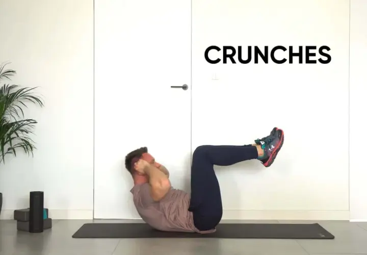Mężczyzna wykonuje ćwiczenie ab crunch na macie.