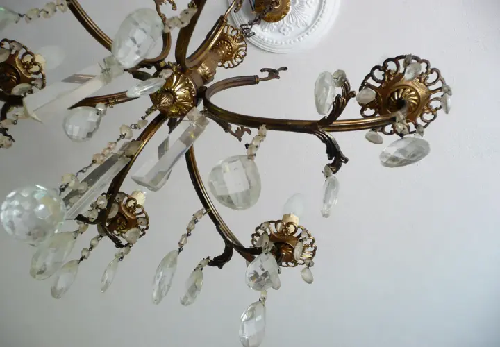 Dettagli di un lampadario a gocce in ottone con cristalli trasparenti. Un'idea su come rimodernare un lampadario a gocce con un tocco di eleganza.