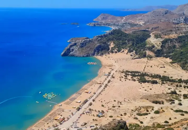 Malownicze plaże Rodos z turkusową wodą, leżakami i wodnym parkiem rozrywki. Widok z góry na wybrzeże i górzysty krajobraz.