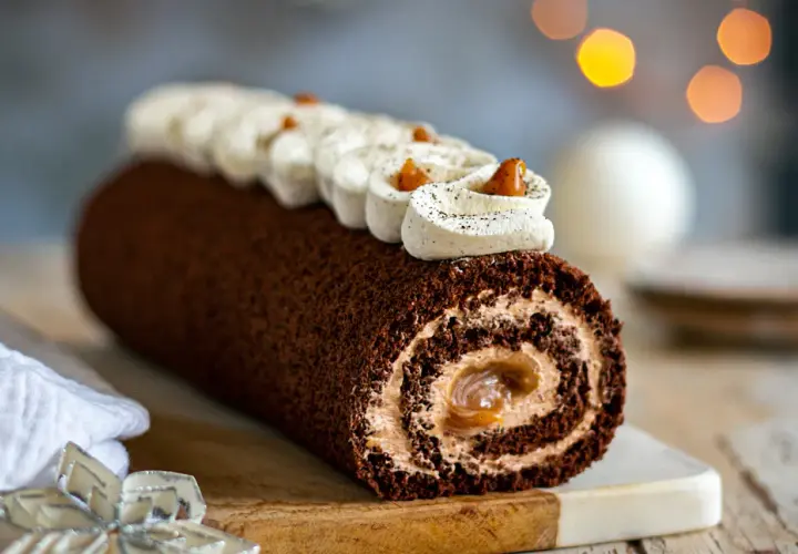 Une délicieuse buche chocolat au lait, roulée et garnie de crème onctueuse, prête à être dégustée.