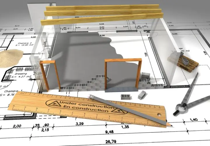 Plans de construction, outils et matériaux suggèrent un projet en cours, mais le panneau "En construction" et la règle indiquent que le permis de construire annulé a stoppé net les travaux.