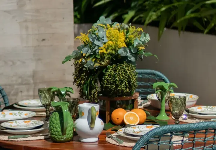 A vibrant tablescape with citrus-themed plates, green pitchers, and a lush floral arrangement. This modern everyday dining table decor evokes a fresh, summery feel.
