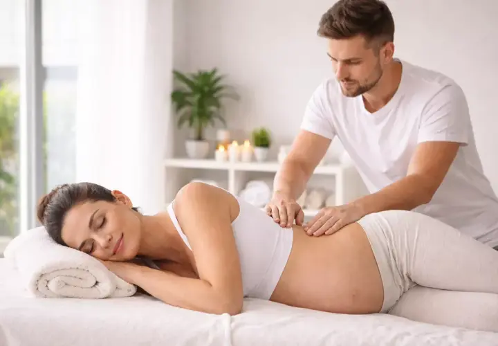 Donna incinta rilassata riceve un massaggio prenatale da un terapista esperto.