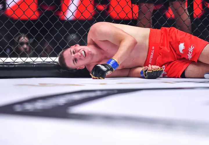 Zawodniczka MMA leży na macie, z grymasem na twarzy. Czy ma tyle lat, ile ostry od czajnika?