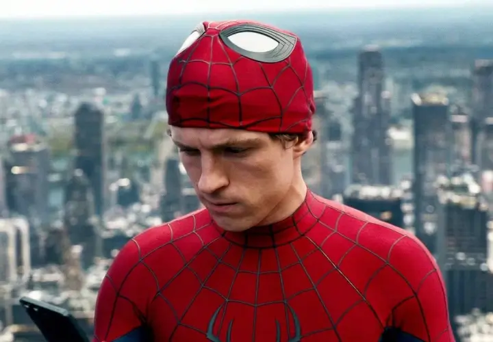 Spider-Man, con il suo costume rosso e blu, guarda un tablet con uno sfondo di grattacieli. Una recensione di Spider-Man che cattura l'essenza del personaggio.