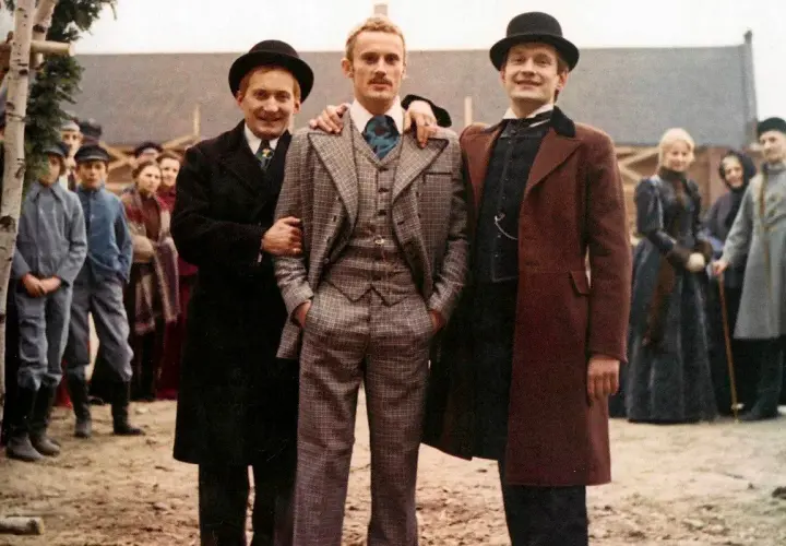 Trzech mężczyzn w melonikach i eleganckich strojach, jak z najlepsze filmy ranking. W tle tłum ludzi.