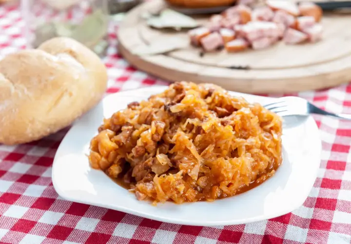Pyszny bigos na talerzu. Przyprawy do bigosu krok po kroku w jakiej kolejności dodawać je do kapusty, by uzyskać idealny smak.