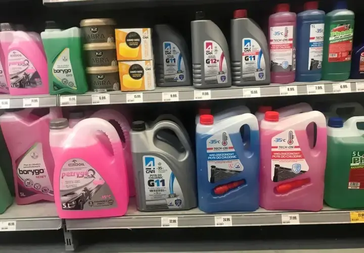 Półka sklepowa z płynami do chłodnic: zielony płyn do chłodnic "borygo EKO", różowe i niebieskie płyny "TECH-ON", szare "G11" i "G12+".