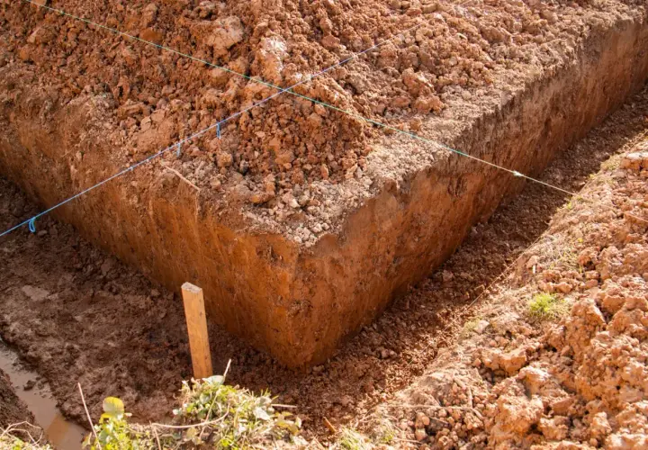 Wykonano wykopy pod fundamenty. Widać głębokie okopy ziemi, wyznaczone sznurkami.