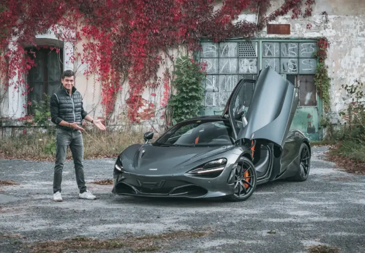 Mężczyzna prezentuje szarego McLarena 720S z otwartymi drzwiami. Zastanawiasz się nad mclaren 720s cena?