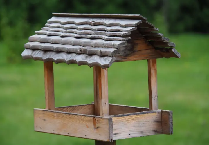Drewniany karmnik dla ptaków diy, z dachem pokrytym łupkiem, gotowy na zimowych gości.