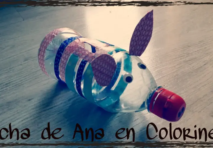 Hucha de hucha manualidades hecha con botella, decorada con cintas de colores y ojos saltones. ¡Un cerdito divertido!