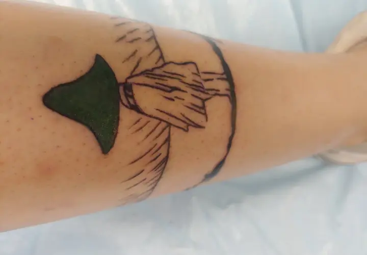 Nowy tatuaż muminki na nodze. Zielony kapelusz i zarys postaci.