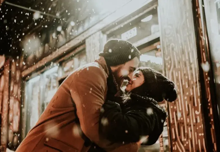 Coppia che si abbraccia sotto la neve, con lui che la guarda intensamente. Se lui non ti desidera, non ti ama.