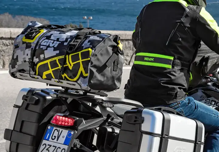 Motociclista con equipaje en maletas laterales y bolsa trasera. Es correcto transportar el equipaje en maletas laterales para viajes largos.