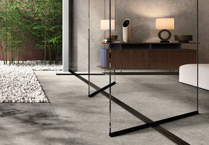 Un elegante soggiorno con arredi moderni e un giardino zen con bambù, evocando la raffinatezza del cotto d'Este.