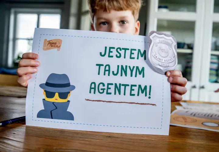 Chłopiec trzyma kartkę z napisem "Jestem tajnym agentem!" i rysunkiem szpiega. Idealne do gry szpiegowskie.