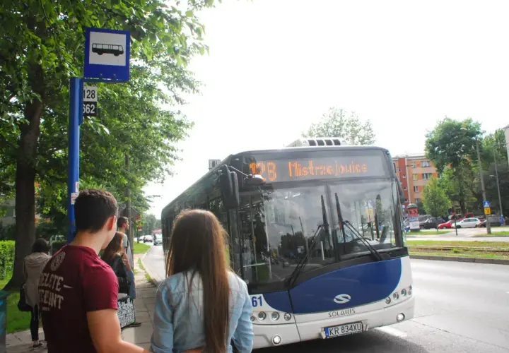 Autobus MPK na przystanku z pasażerami, znak z ikoną autobusu.