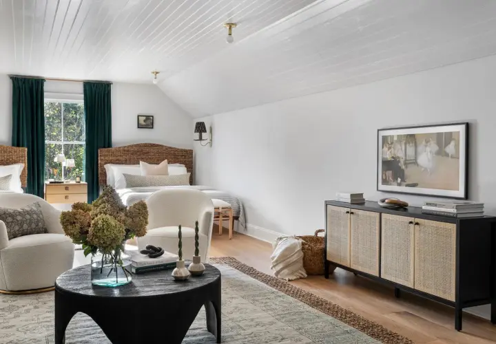 A cozy bedroom with a mix of dark and light wood furniture, featuring rattan headboards, a dark wood cabinet, and light wood nightstands.