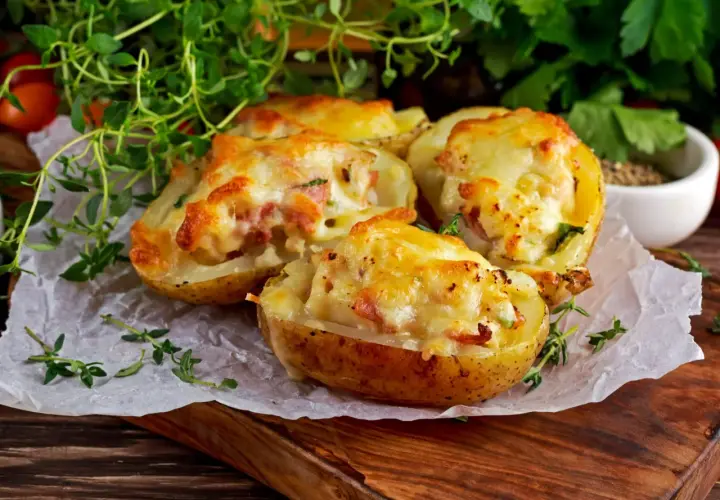 Zapiekane ziemniaki z serem i boczkiem, podane z ziołami. Czy pieczone ziemniaki są lekkostrawne? Tak, jeśli są dobrze przygotowane.