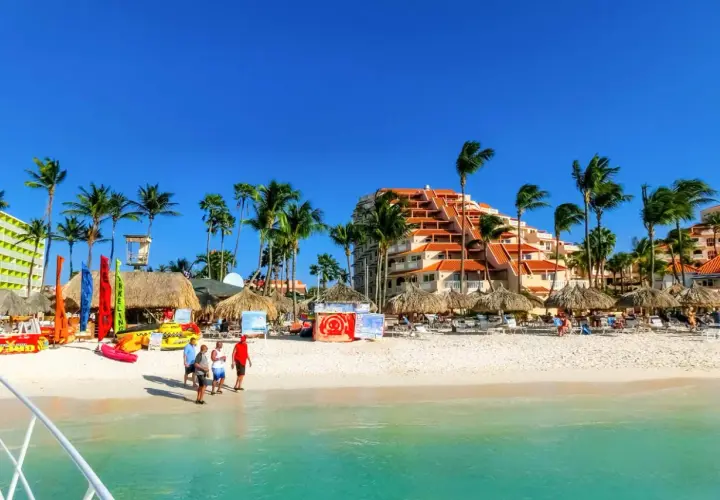 Aruba, gdzie jest raj na ziemi! Biały piasek, palmy, turkusowa woda i hotel z pomarańczowym dachem. Idealne miejsce na wakacje.