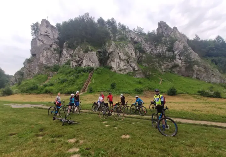 Grupa rowerzystów na tle skalnych ostańców. Jura Krakowsko-Częstochowska rowerem to wspaniała przygoda.