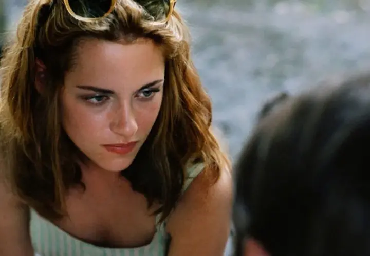 Kristen Stewart w "Zmierzchu" miała 17 lat. Na zdjęciu widać jej twarz z okularami na głowie.